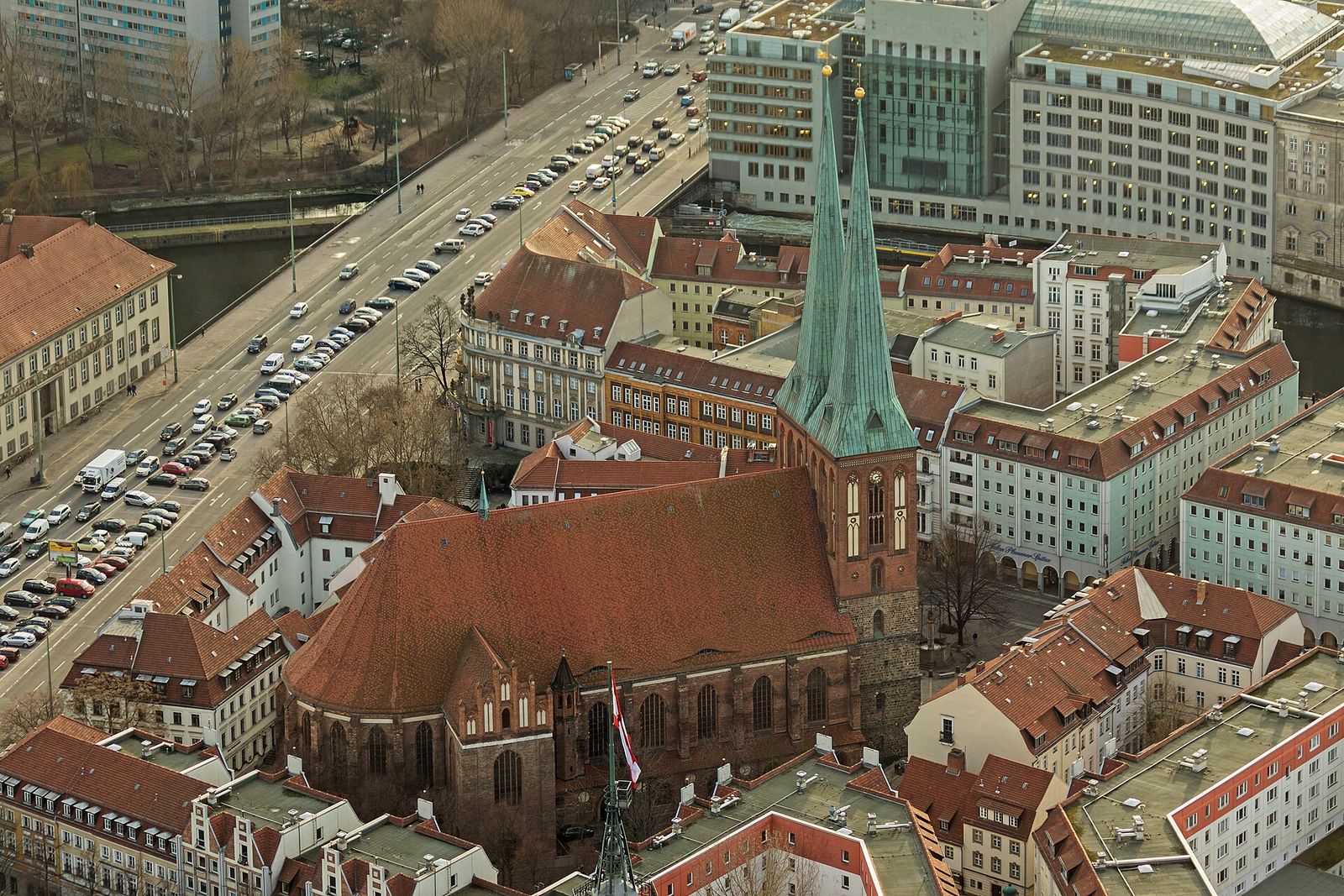 Aussicht vom Fernsehturm auf die Nikolaikirche mit zwei spitzen Türmen und die roten Dächer des Nikolaiviertels