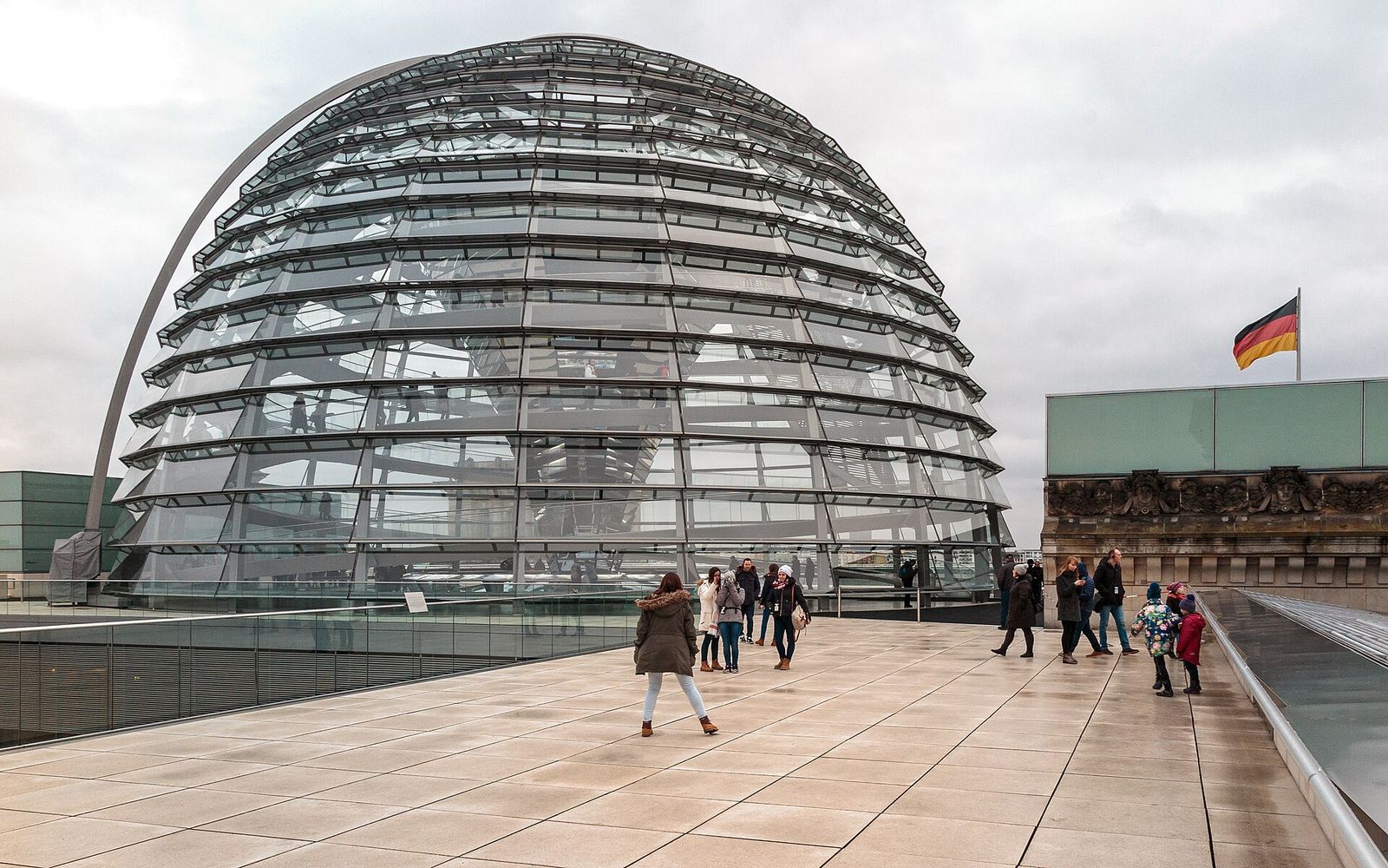 Die Glaskuppel auf dem Reichstagsgebäude, davor Besucher auf der Dachterrasse